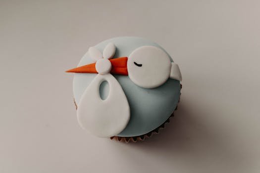 A charming cupcake decorated with a stork design, perfect for baby showers and celebrations.